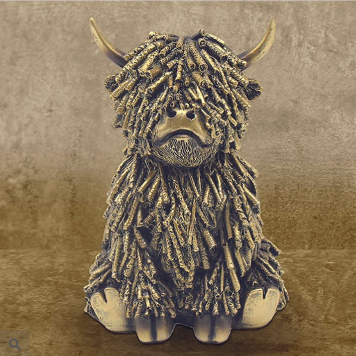 Gold coloured shaggy Highland Cow, sitting