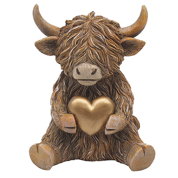 Happy Highland Cow Sitting Holding a Gold Heart