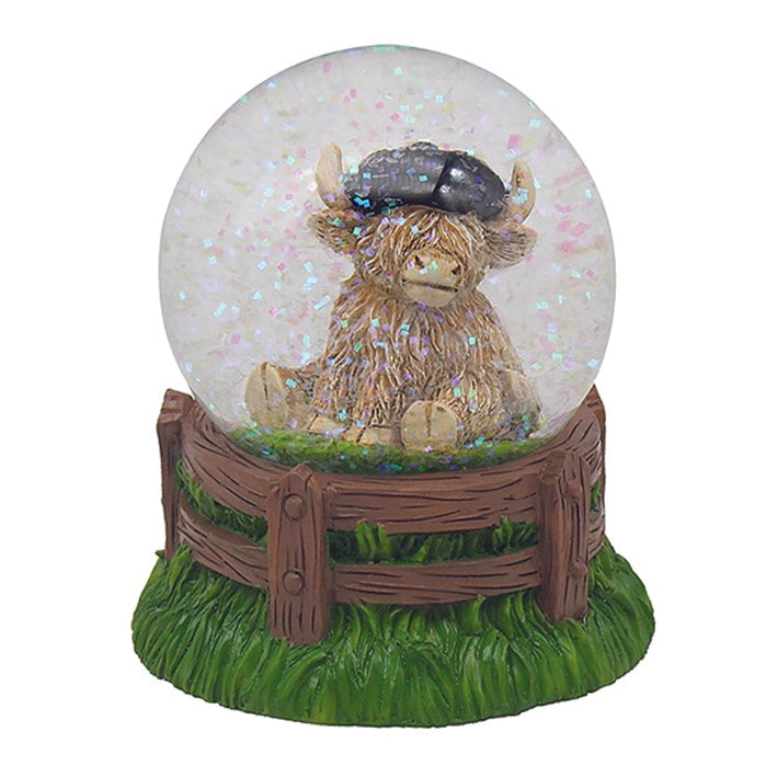 Waterglobe - Sitting Highland Cow with Hat in a Water Globe with Coloured Glitter