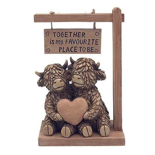 Hughie the Highland Cow couple under sign reading Together is my favourite place to be