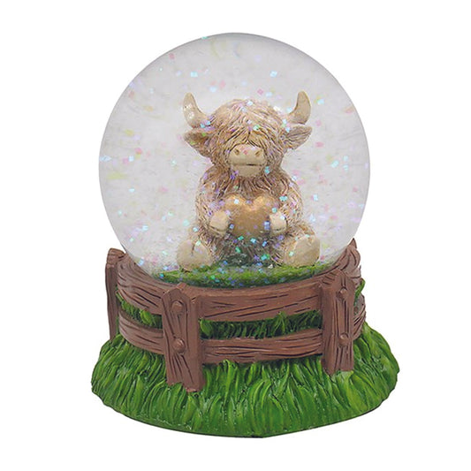 Waterball - Sitting Highland Cow Holding a Gold Heart in a Water Globe with Coloured Glitter